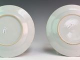 two white plates with gold rims are sitting side by side