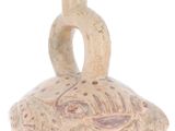 a small vase with a bird on it on a white surface
