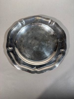 a silver plate on a white table with a black background