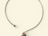 a close up of a necklace with a triangle on it