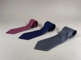 three ties are lined up on a white surface
