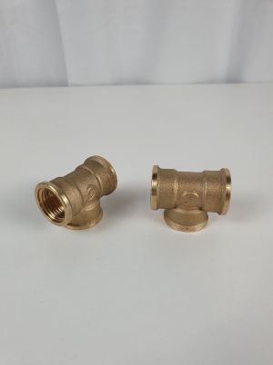 une paire de robinets en laiton posés sur une surface blanche