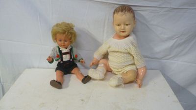 two dolls that are sitting on a white table