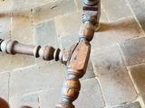 a hand that is holding a piece of wood on a table