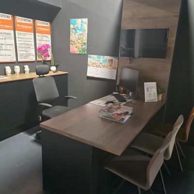 a desk with chairs and a television in a room