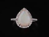 une bague en oplite blanche et diamant sur fond noir