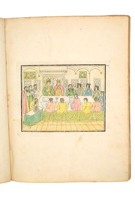 un vieux livre sur lequel figure le dessin d'un groupe de personnes assises autour d'une table