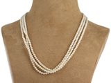 a three strand pearl necklace on a mannequin torso