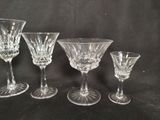 four wine glasses sitting on a table with a black background