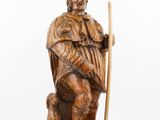 an image of a wooden statue of a man with a staff