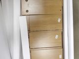 a tall wooden dresser with four drawers in a room