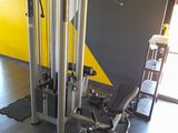 a gym room with a yellow wall and a black and white floor