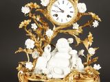 une horloge posée sur une table sur laquelle se trouve une statue