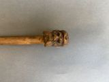 a close up of a wooden stick with a face on it