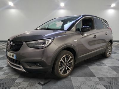 the grey car is parked on a checkered floor in a garage