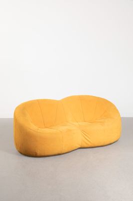 un canapé jaune posé sur un sol gris
