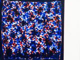 blue, red, and white abstract painting on a white wall