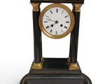 a black and gold clock sitting on a white surface