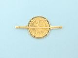a gold pin with a coin on it on a blue surface