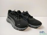 une paire de baskets noires posées sur une surface blanche