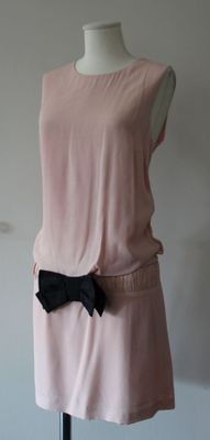 a dress on a mannequin with a black bow on it