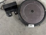 a close up of a robot vacuum on the ground with a charger