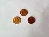 trois pièces posées sur un morceau de papier, sur une table