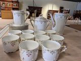 Plusieurs tasses et soucoupes sont disposées sur une table dans une pièce