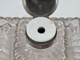 a glass candle holder with a white candle in it