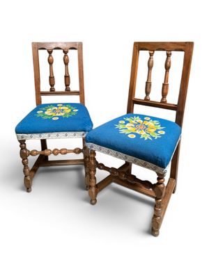 deux chaises en bois avec une assise bleue et un motif floral sur le dossier