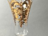 a glass with a gold design on it on a table