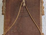 a wooden plaque hanging on the wall with a rope