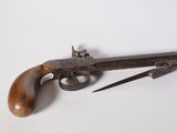 un gros plan d'un pistolet et d'un couteau posés sur une surface blanche