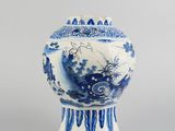 blue and white vase with a bird design on the top of it