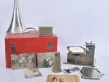 une boîte rouge ornée d'images et surmontée d'une clochette argentée