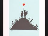 a framed picture of a couple holding hands on top of a hill