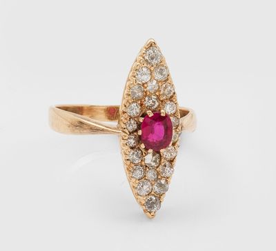 gros plan d'une bague en or avec un rubis et des diamants