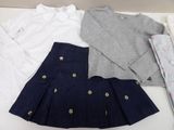 three pieces of clothing are laid out on a white table