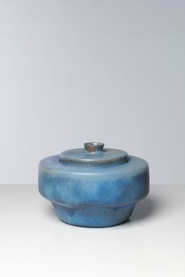 un saladier bleu avec un couvercle posé sur une table
