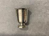 a silver cup sitting on a gray surface
