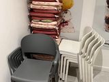 a stack of chairs and a chair in the corner of a room