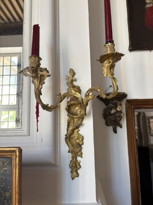two candles that are on the wall next to a picture