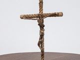 a cross made out of rope on a wooden table