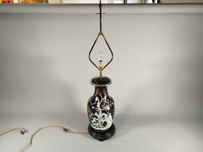 un vase noir et blanc auquel est suspendu un verre