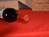 a bottle of wine sitting on a table with a red cloth