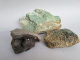 trois pierres de couleurs différentes posées les unes à côté des autres sur une surface blanche