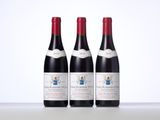 three bottles of red wine sitting on top of a table