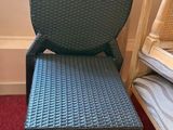 a wicker chair next to a bed in a room