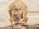 une statue en pierre représentant une personne assise sur un rocher
