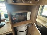 a microwave that is built into a cabinet in the kitchen